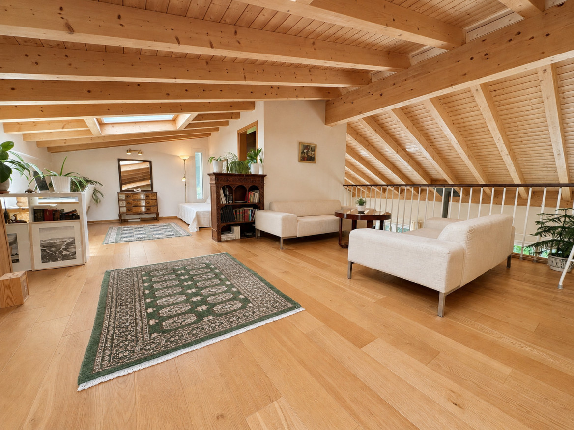 Heller Dachgeschoss-Wohnraum mit sichtbaren Holzbalken