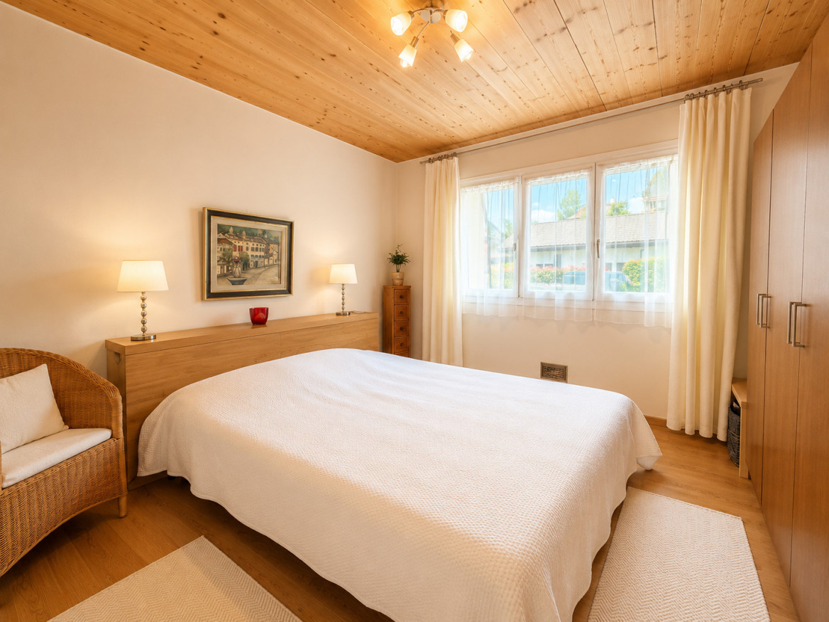 Helles Schlafzimmer mit Holzdecke und großen Fenstern