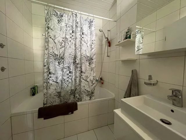 Kleines helles Badezimmer mit Badewanne und Waschbecken