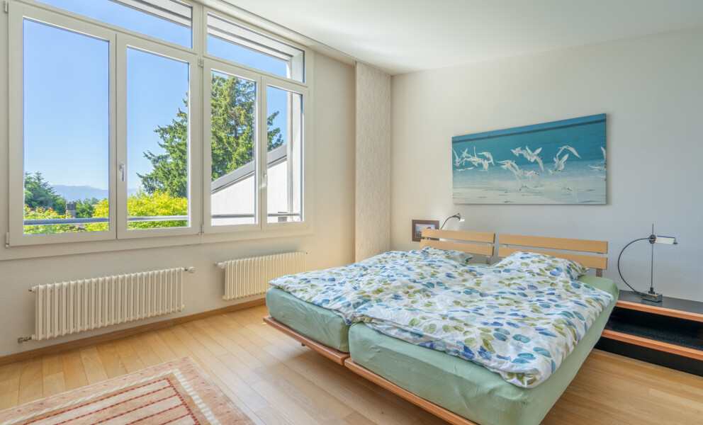 Helles Schlafzimmer mit Doppelbett und großem Fenster
