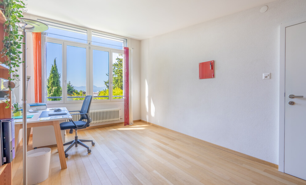 Heller Arbeitsraum mit großem Fenster und Holzboden