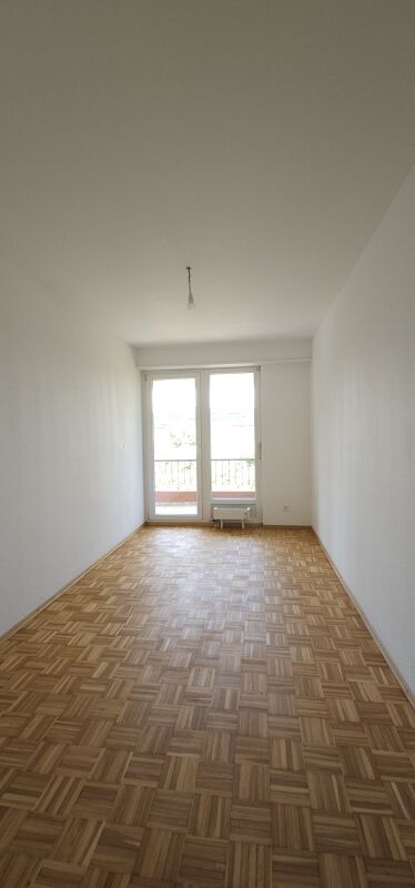 Schmaler leerer Raum mit Balkonfenster
