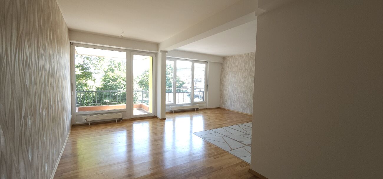 Heller Wohnraum mit Balkon und großen Fenstern