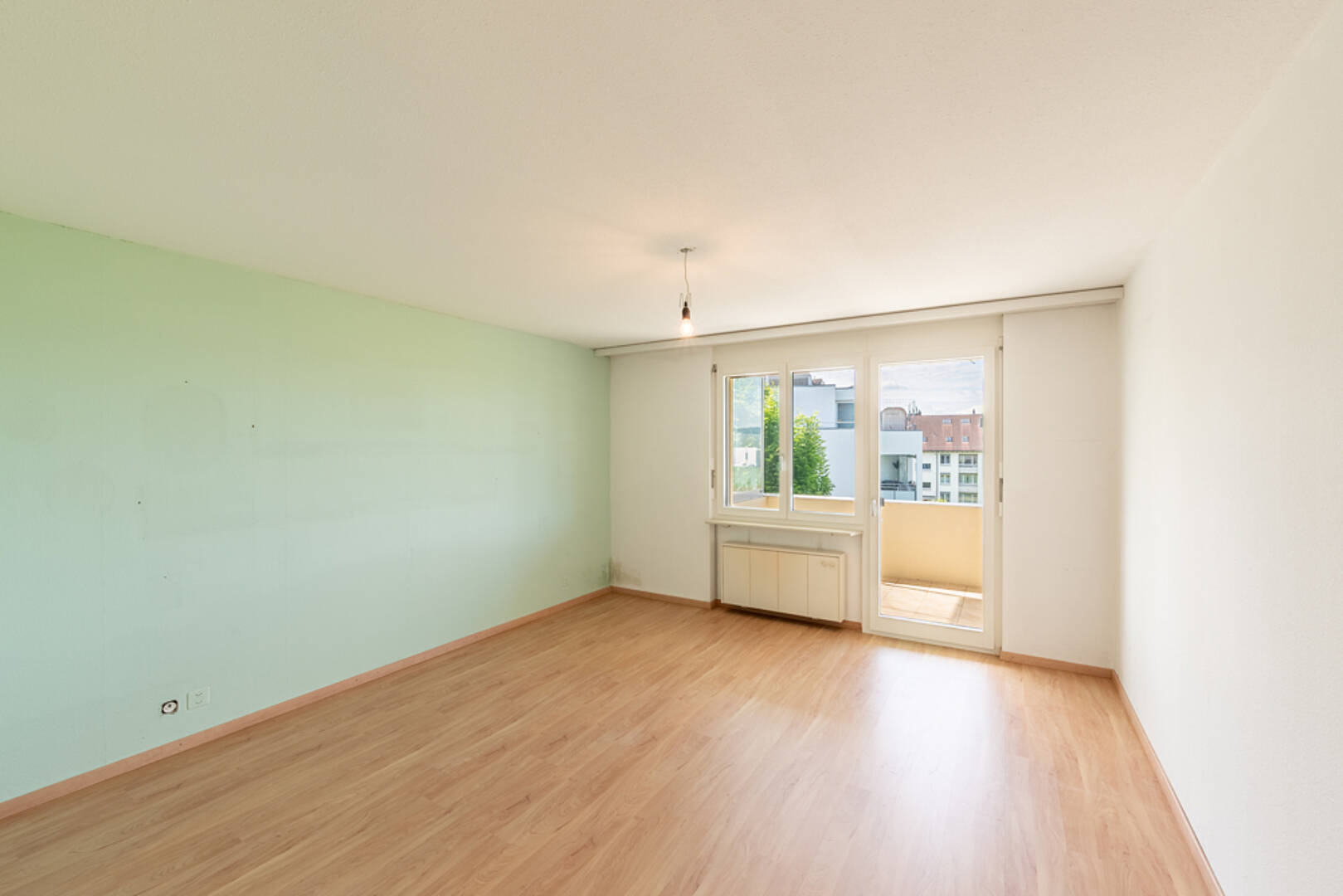 Helles, leeres Zimmer mit Balkonzugang