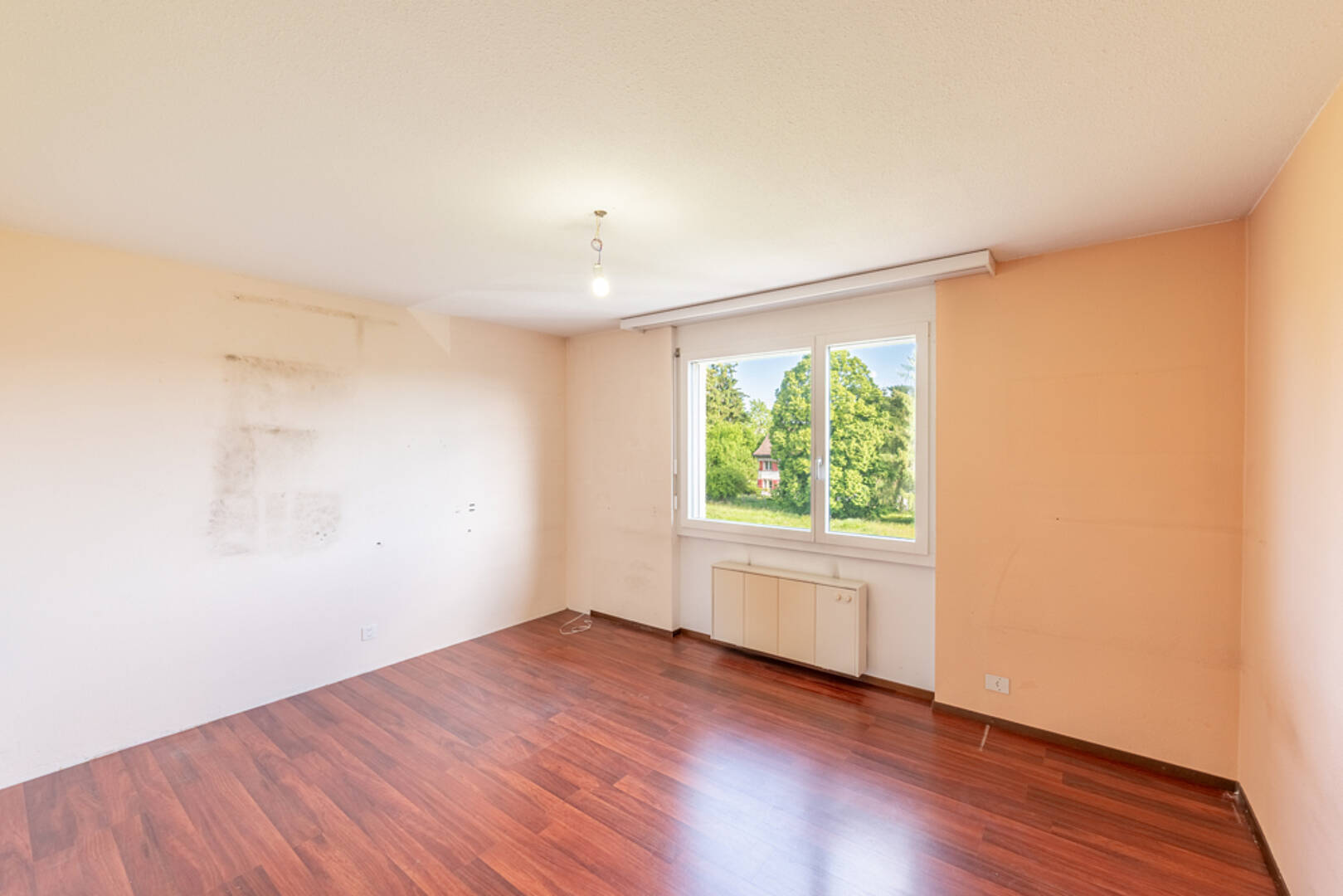 Leeres Zimmer mit Fenster und Laminatboden