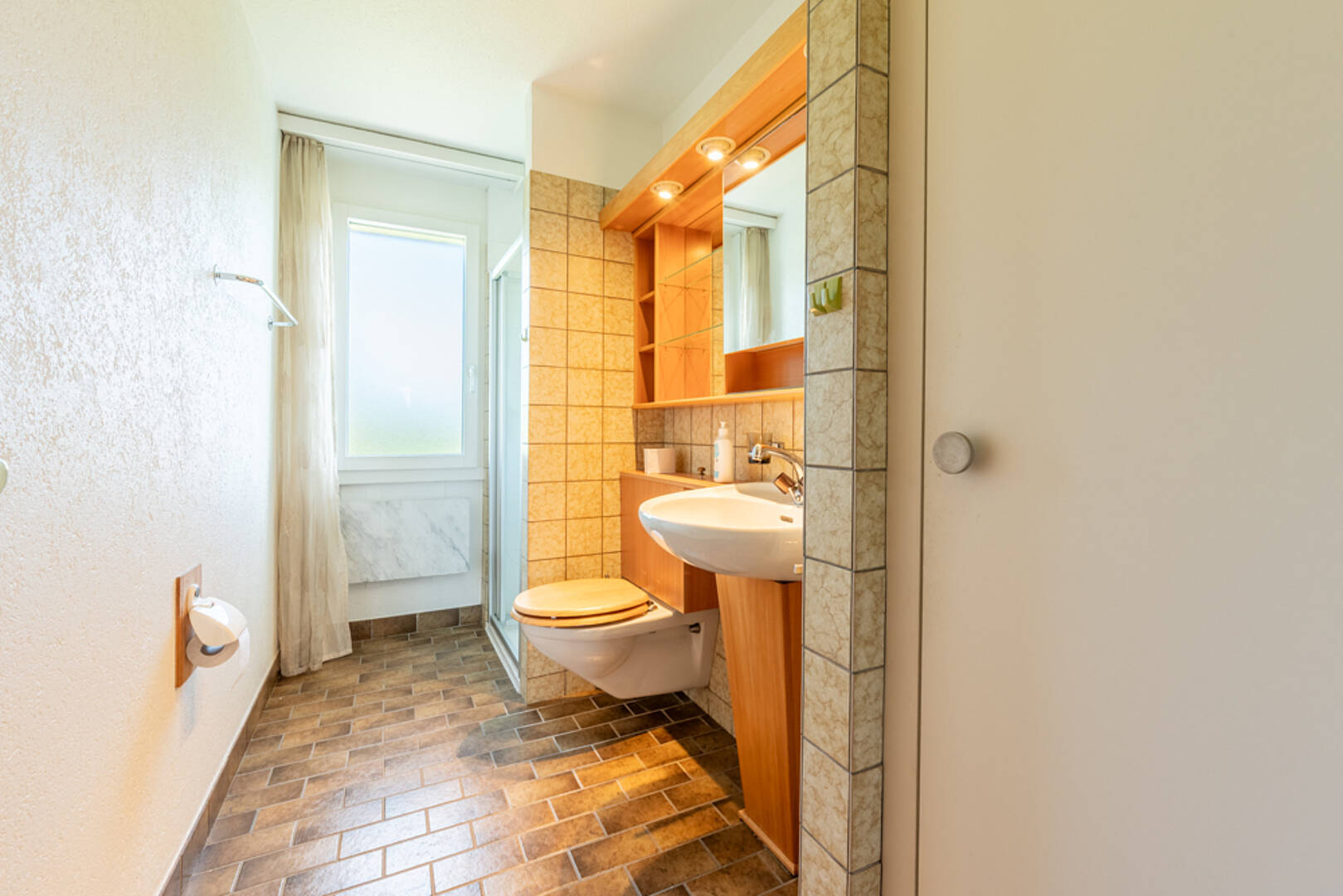 Kompaktes Badezimmer mit Holzwaschtisch und bodennaher Toilette