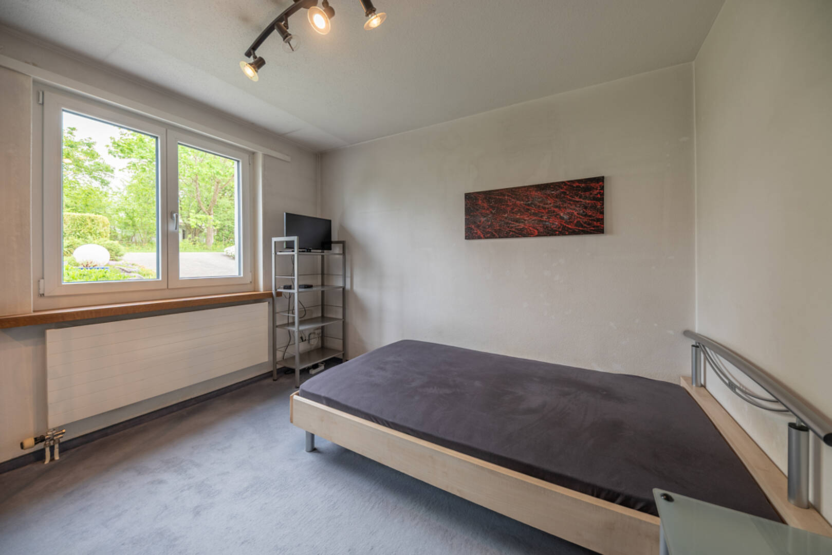 Schlichtes Schlafzimmer mit Blick ins Grüne