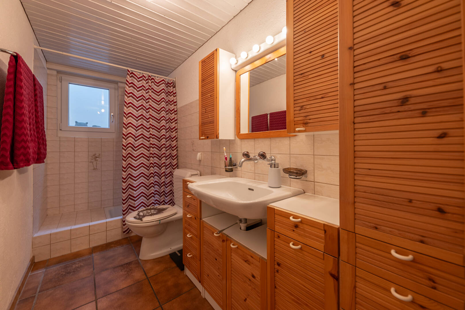 Kompaktes Badezimmer mit Holz- und Fliesenelementen