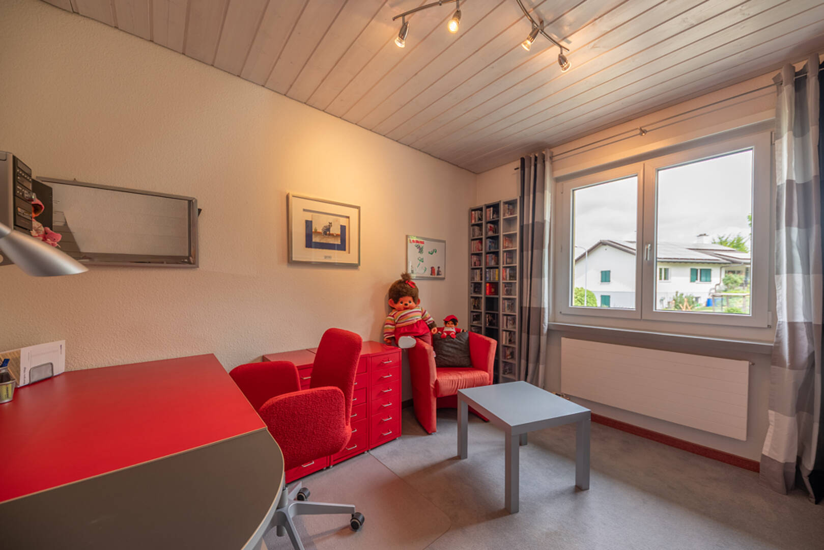 Helles Arbeitszimmer mit roten Möbeln