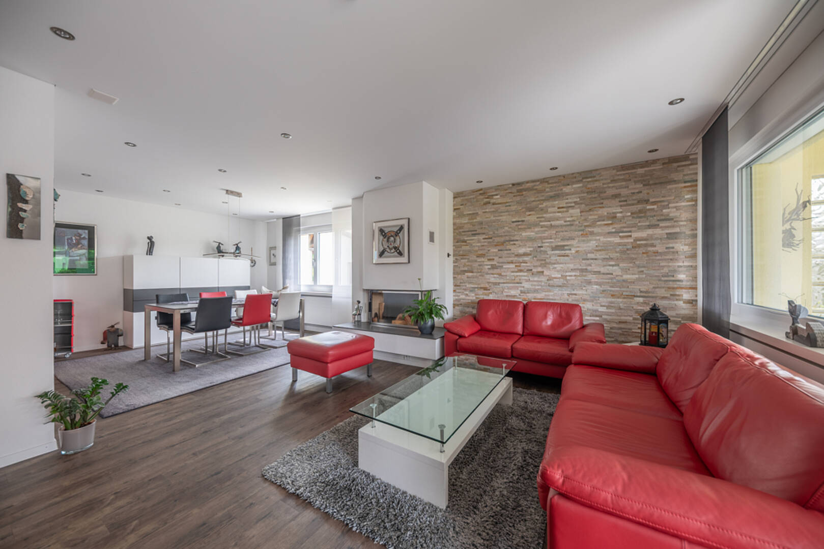 Offener Wohn- und Essbereich mit rotem Sofa