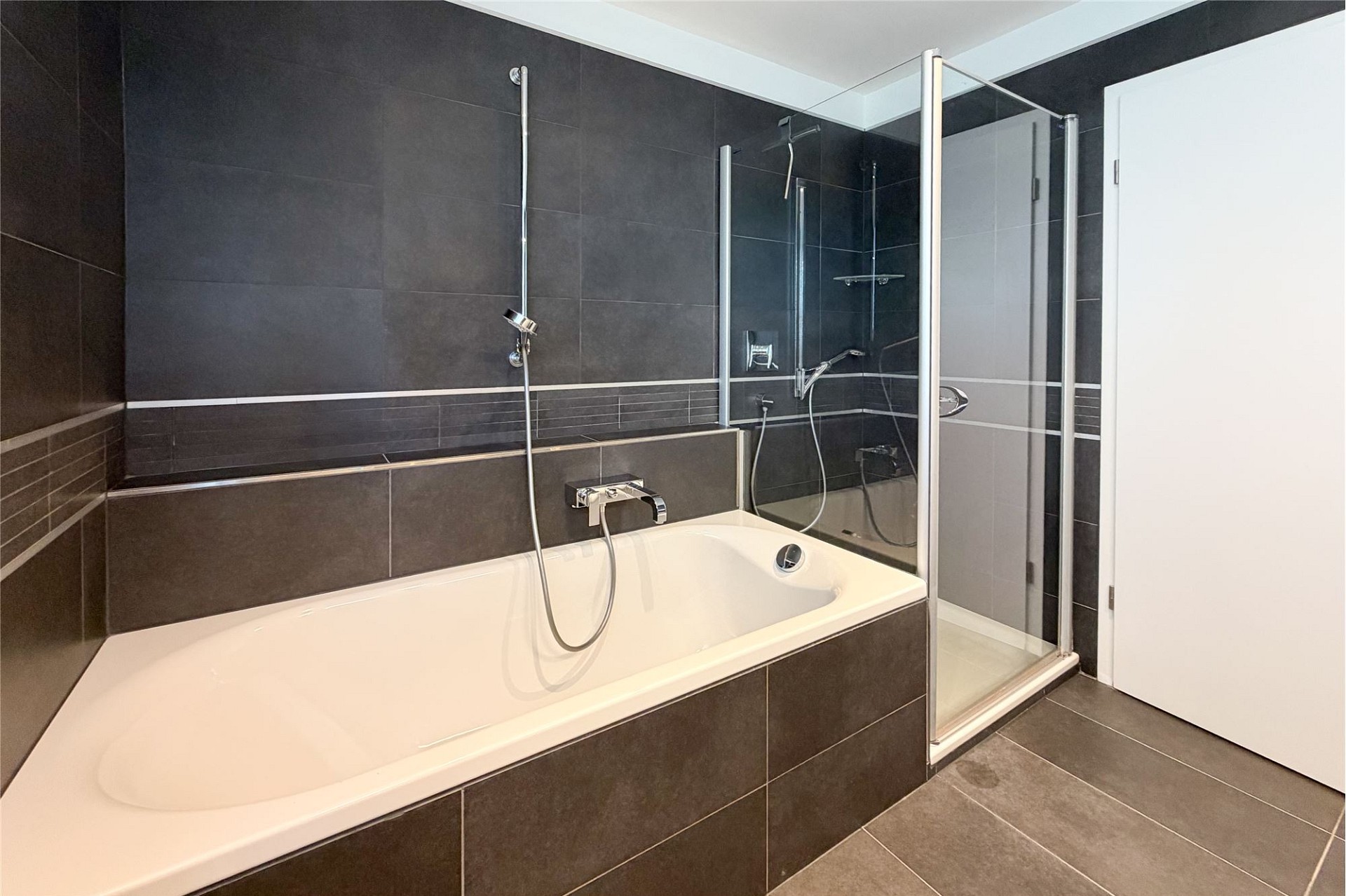 Modernes Badezimmer mit Badewanne und Duschbereich