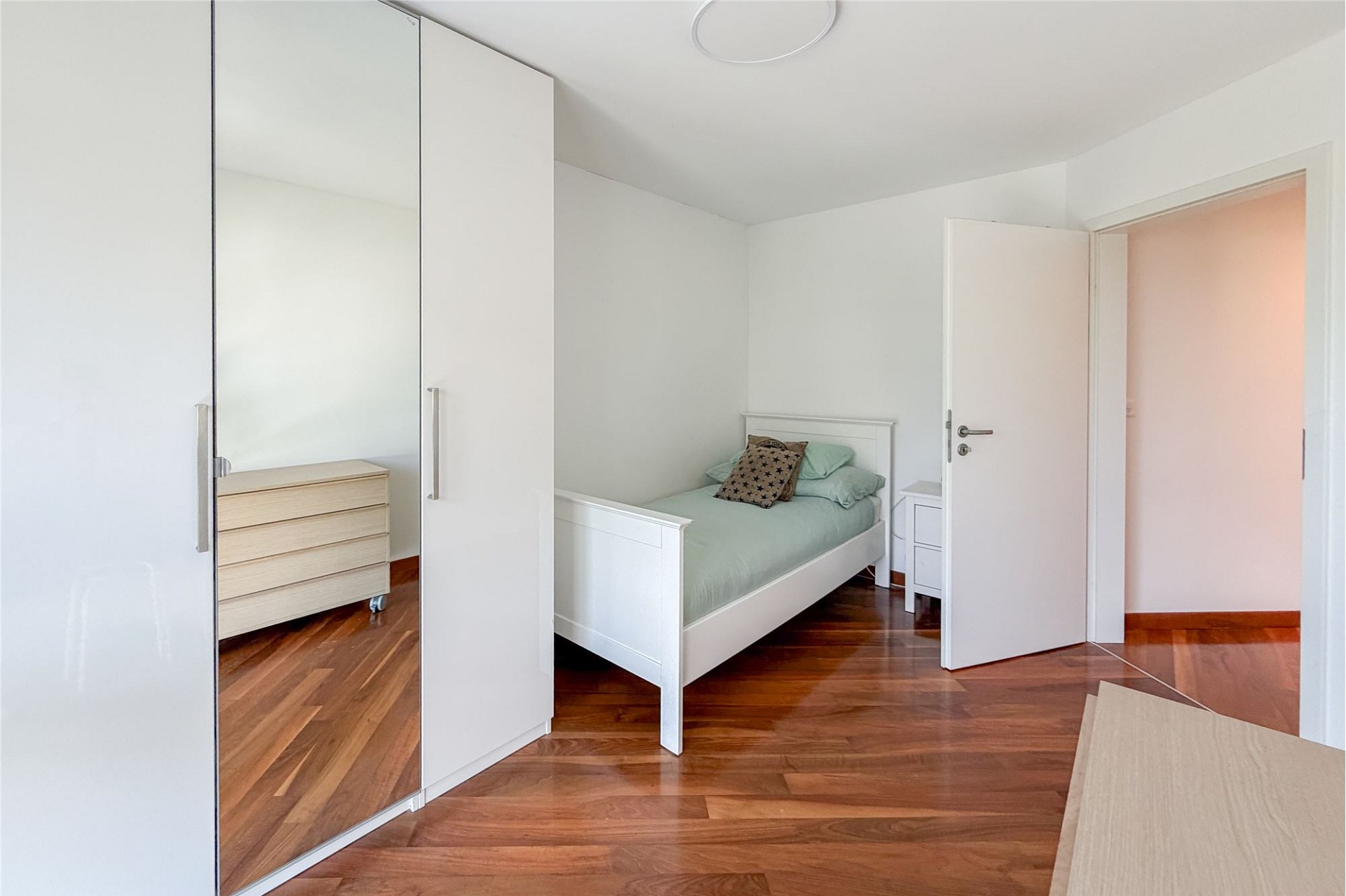 Helles Schlafzimmer mit Kleiderschrank und Bett
