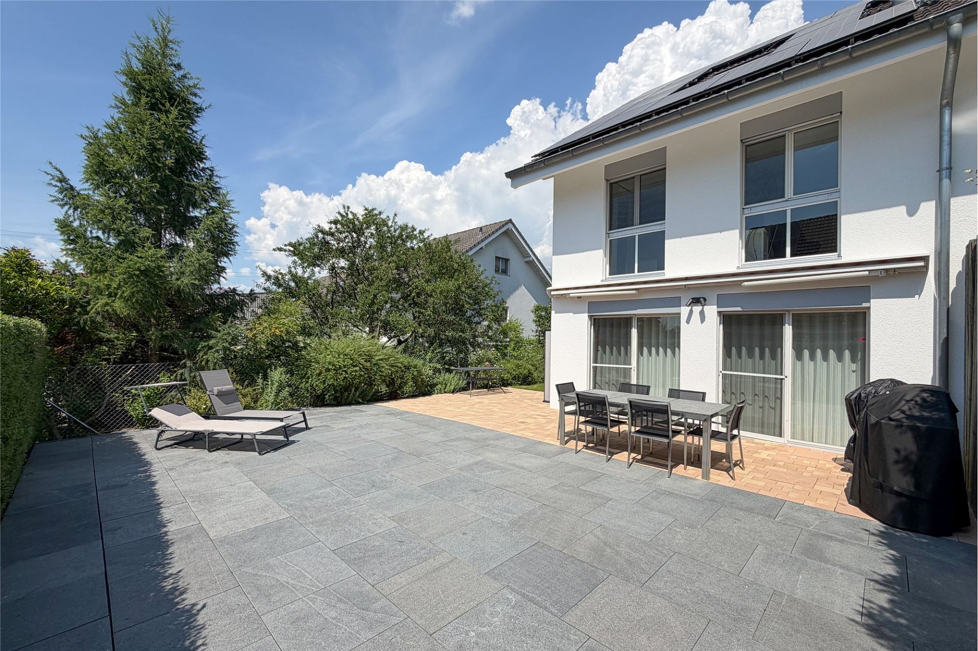 Große Terrasse mit Garten und Wohnhaus