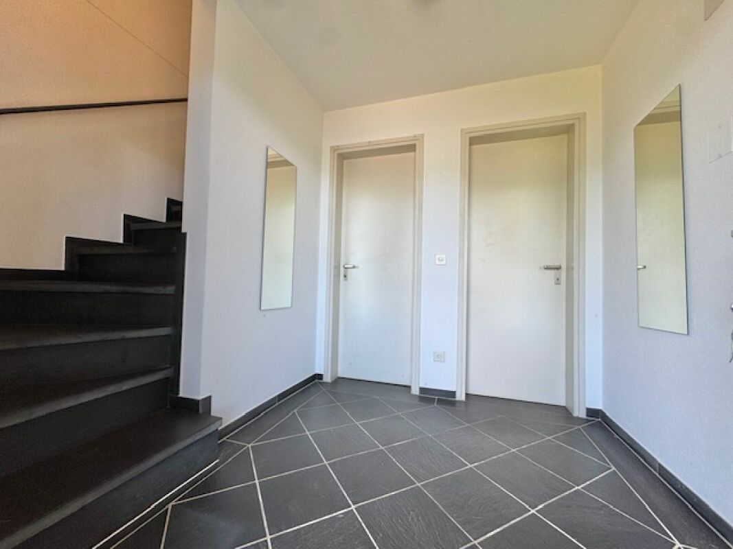 Moderner Eingangsbereich mit Treppe und zwei Türen