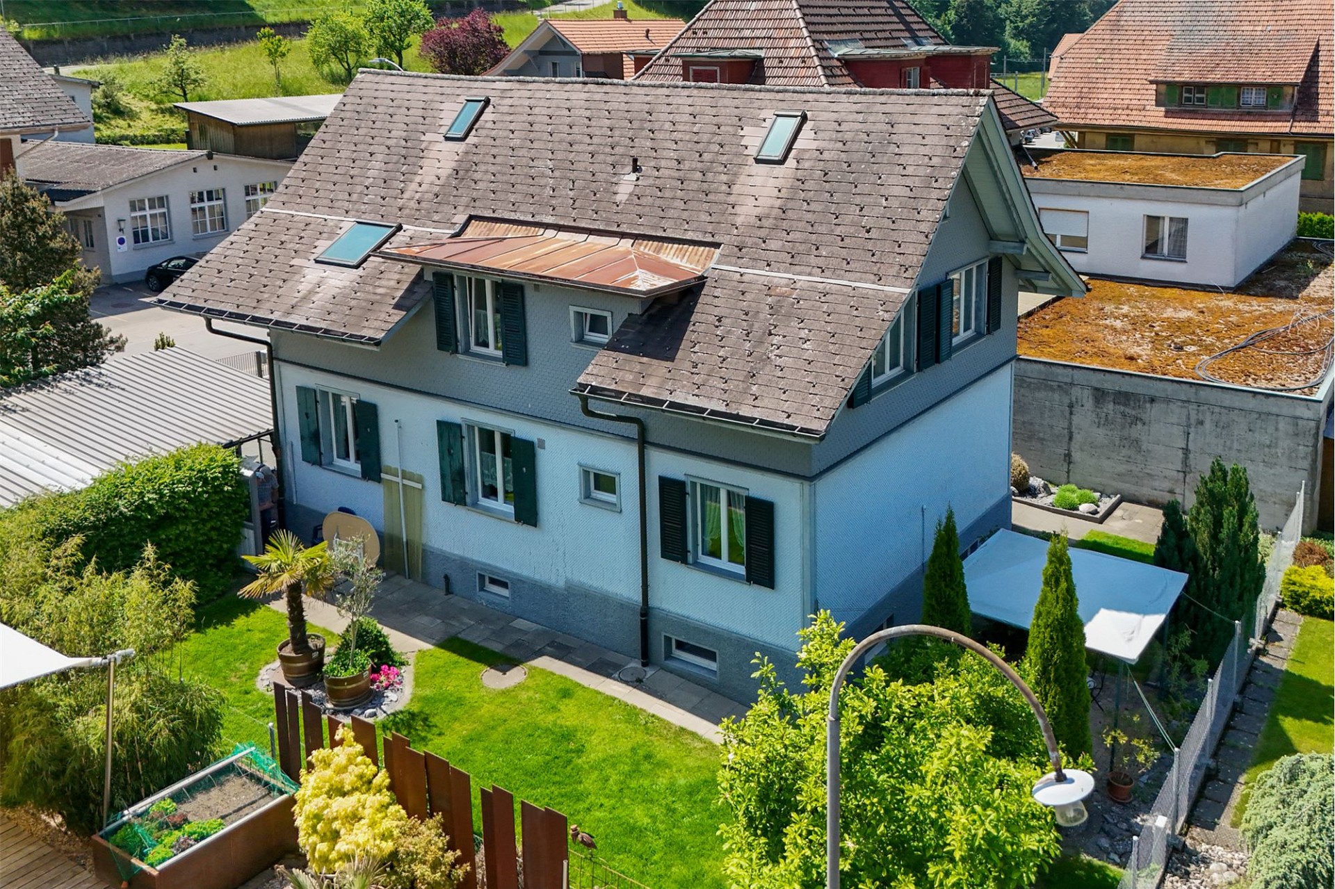 Außenansicht eines Einfamilienhauses mit großem Satteldach und Garten