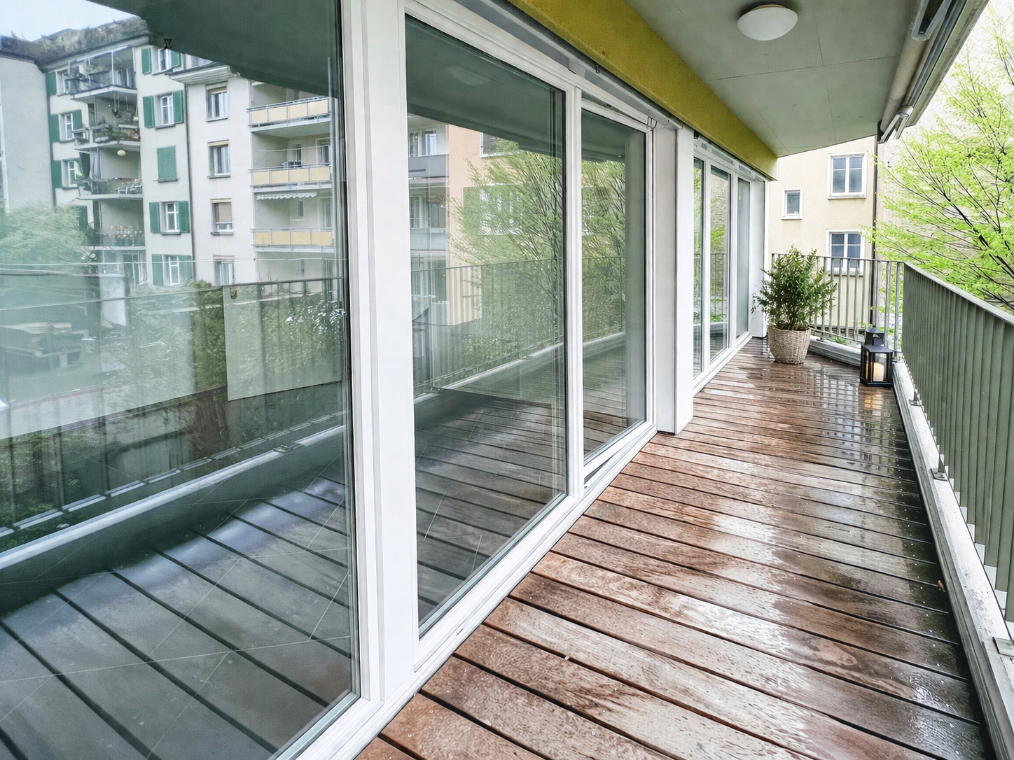 Balkon mit Holzbelag und Glasfronten