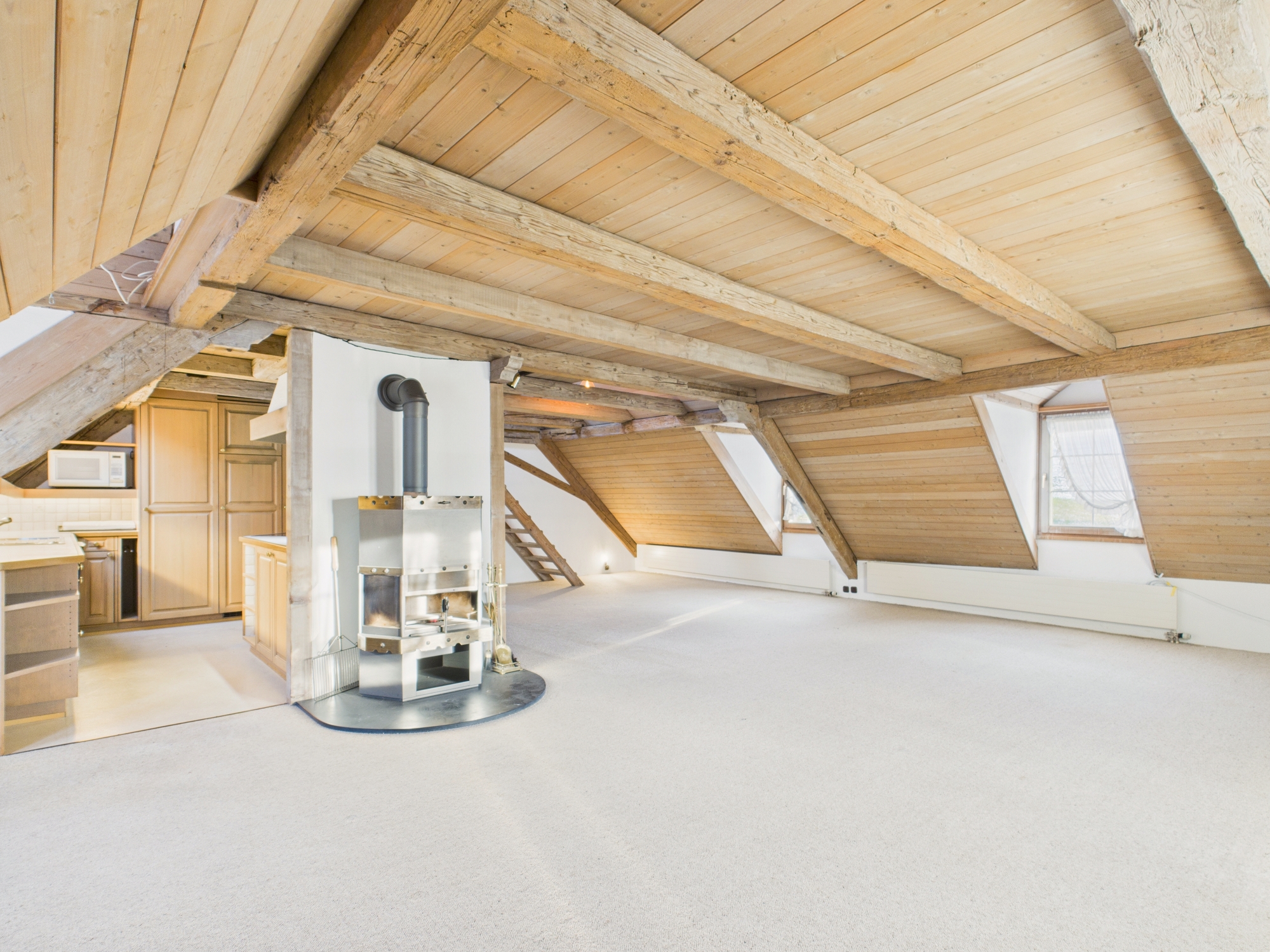 Ausgebauter Dachraum mit Holzdecken und Kaminofen