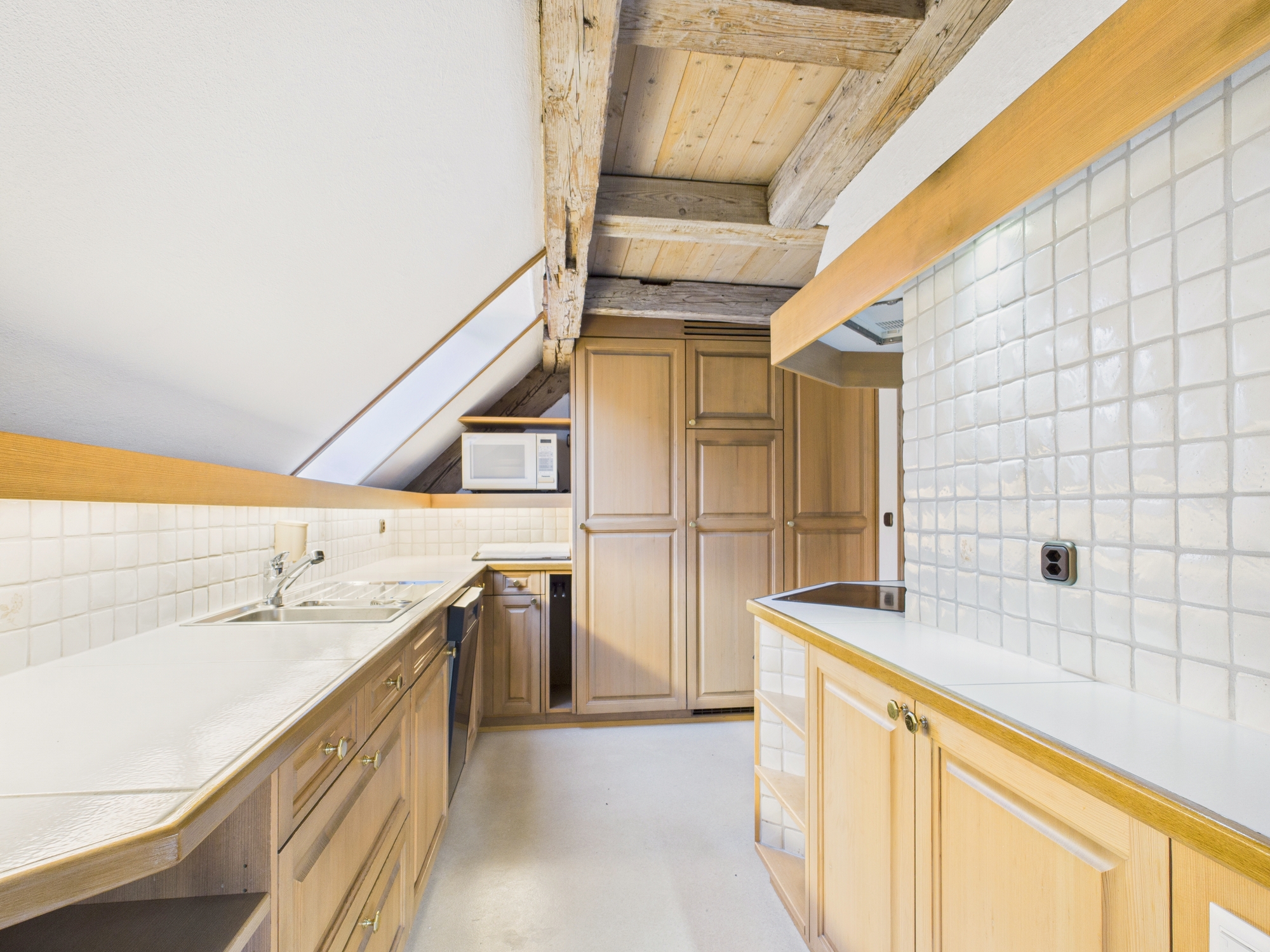 Kleine Dachgeschossküche mit Holzbalken