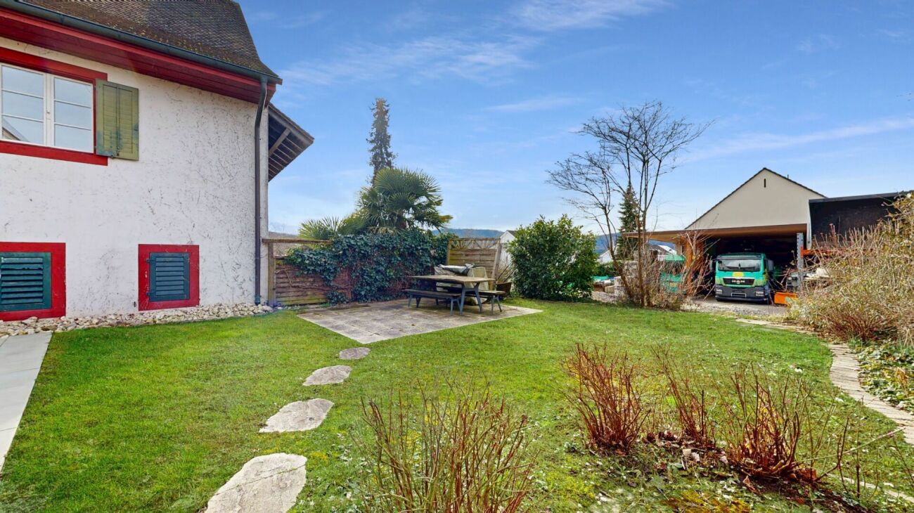 Garten mit Terrasse und Hausfassade