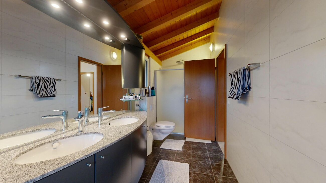 Modernes Badezimmer mit Doppelwaschbecken und Holzdecke