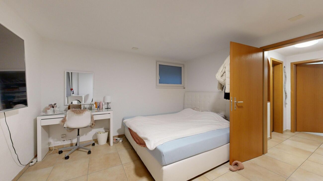 Schlafzimmer mit Schminktisch und Zugang zum Flur
