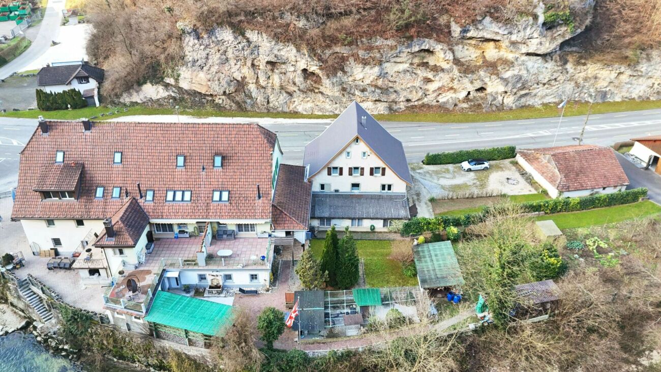 Luftaufnahme eines großen Wohnanwesens am Felsenhang
