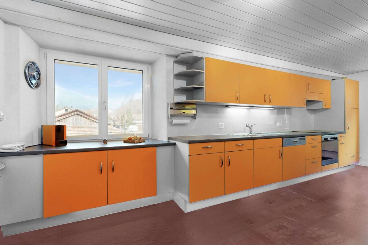 Orangefarbene Einbauküche mit Fenster