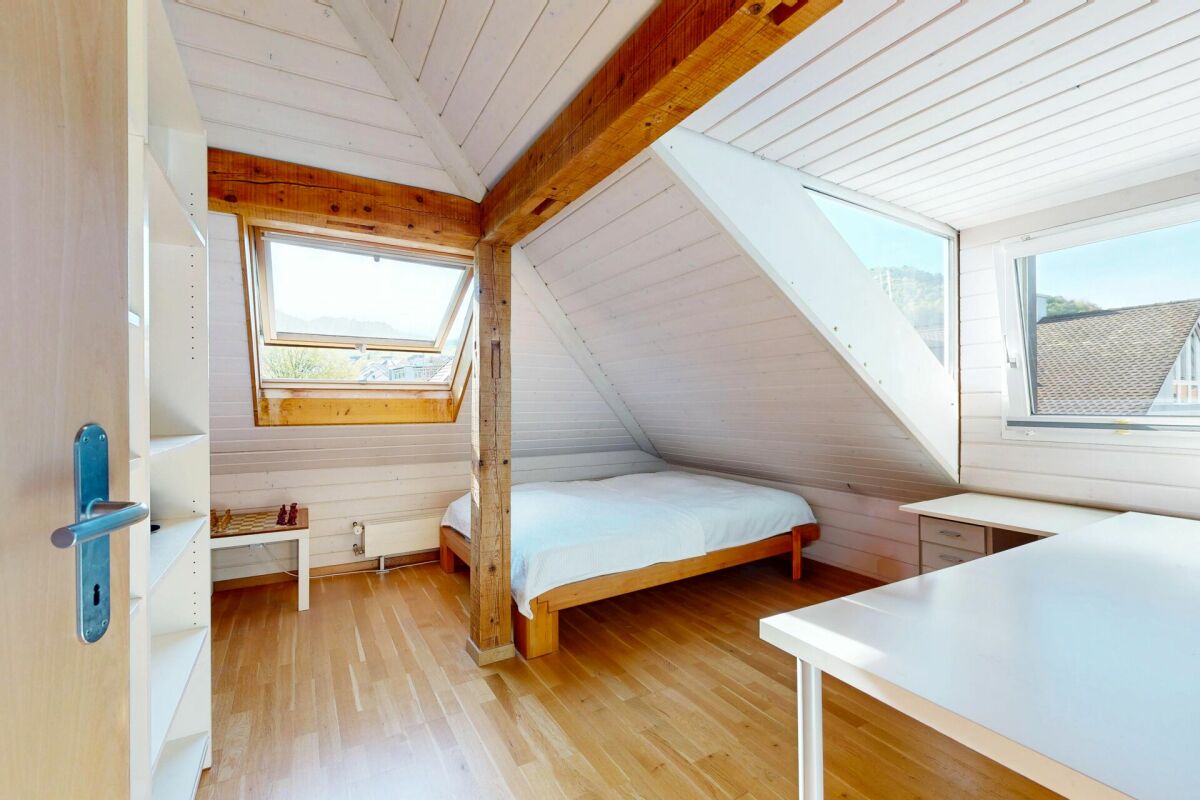 Dachzimmer mit Holzbalken und Dachfenstern