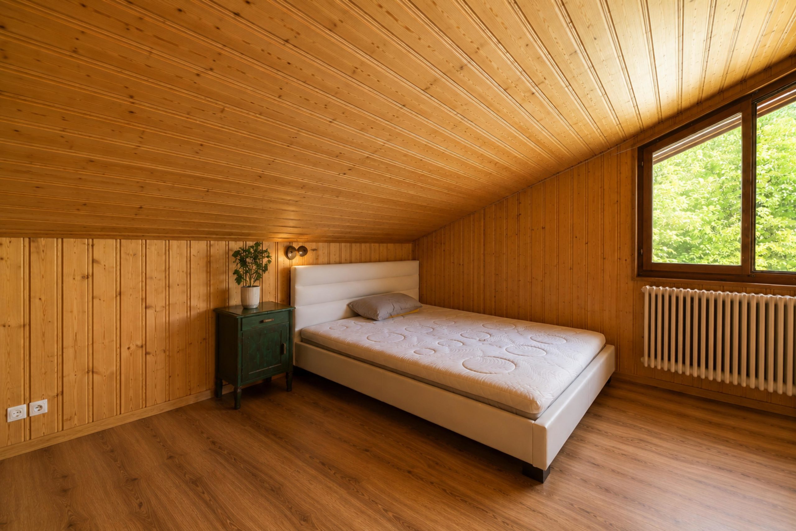 Holzvertäkeltes Schlafzimmer mit Tageslicht