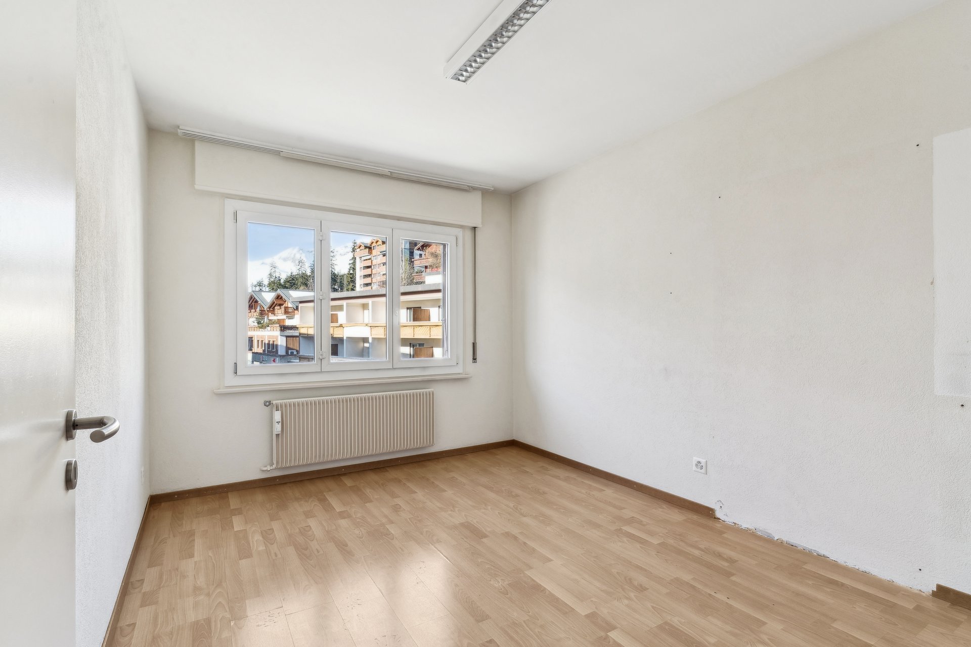 Leerer heller Raum mit Fenster und Heizkörper