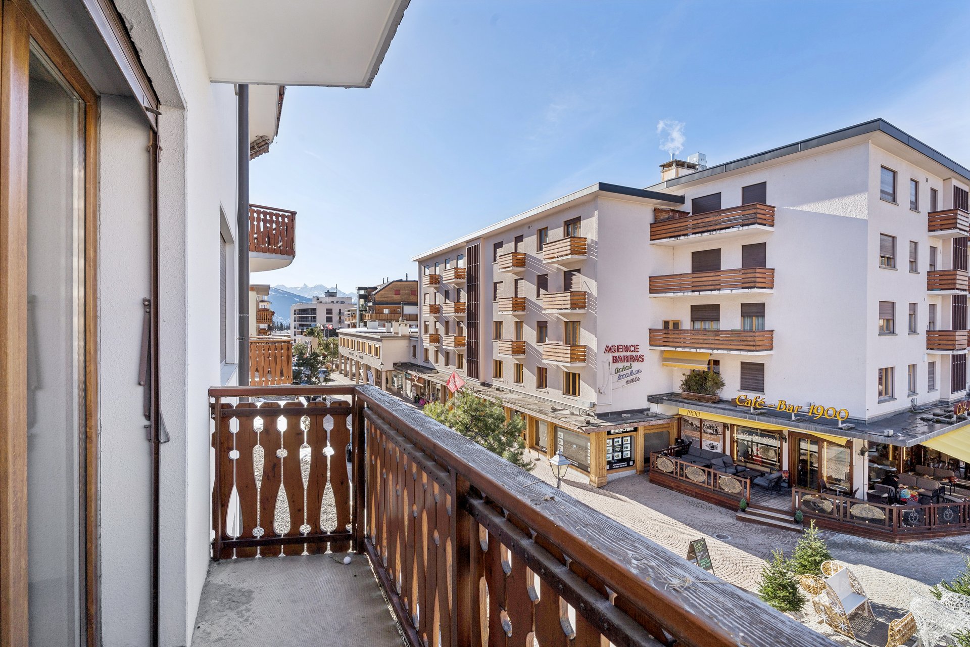 Balkon mit Blick auf Straßenzug und Berge