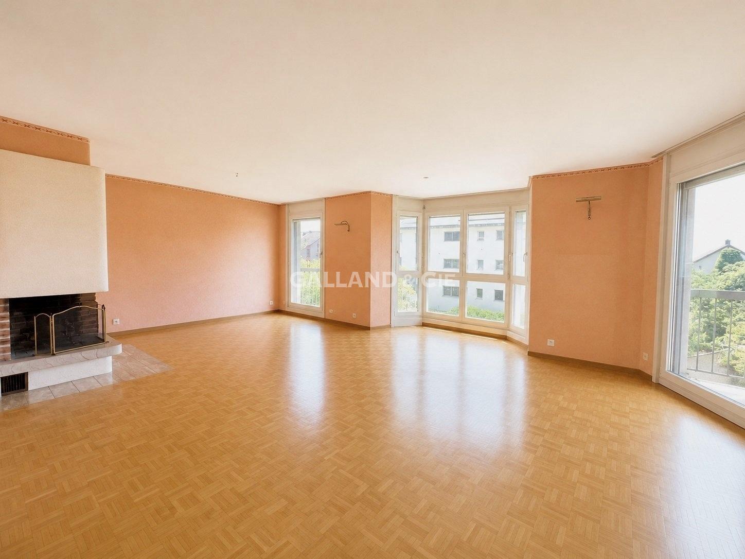 Heller Wohnraum mit Kamin und großen Fenstern
