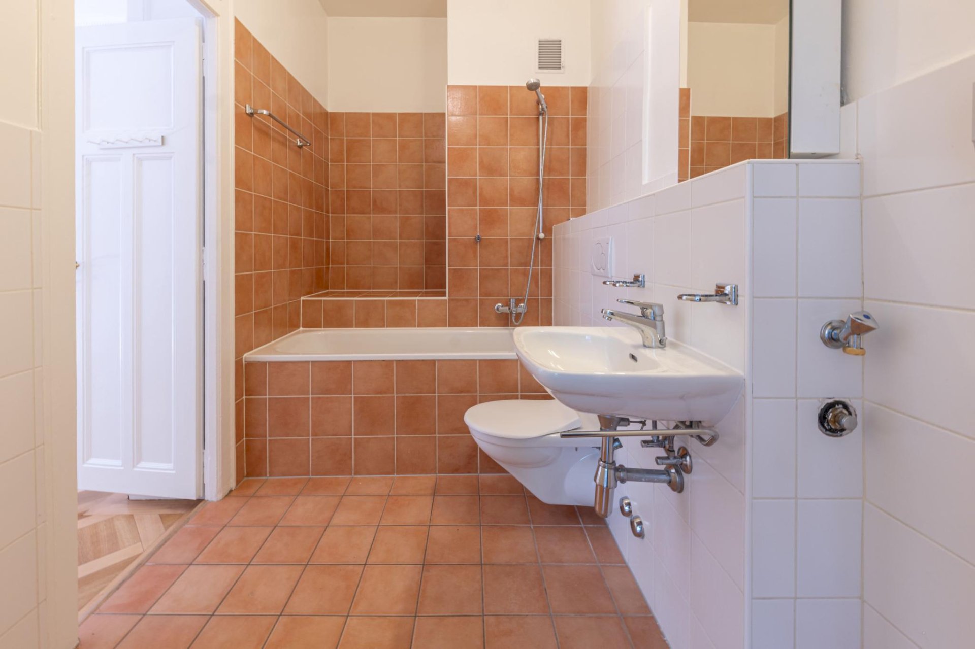 Badezimmer mit Badewanne und wandhängendem WC