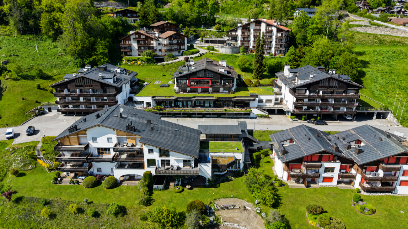 Luftaufnahme einer alpinen Wohnanlage