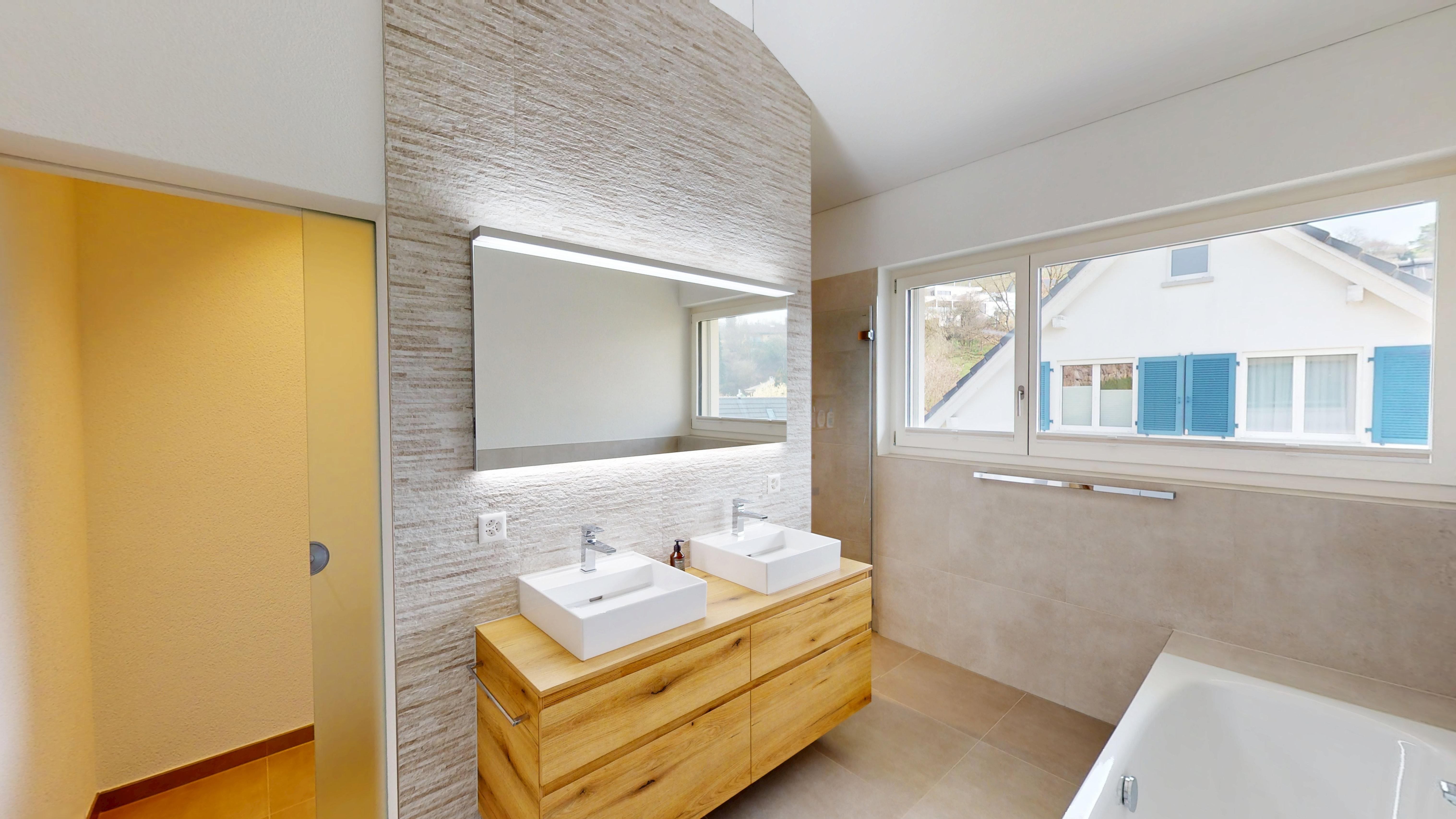 Helles, modernes Badezimmer mit Doppelwaschtisch und Wanne