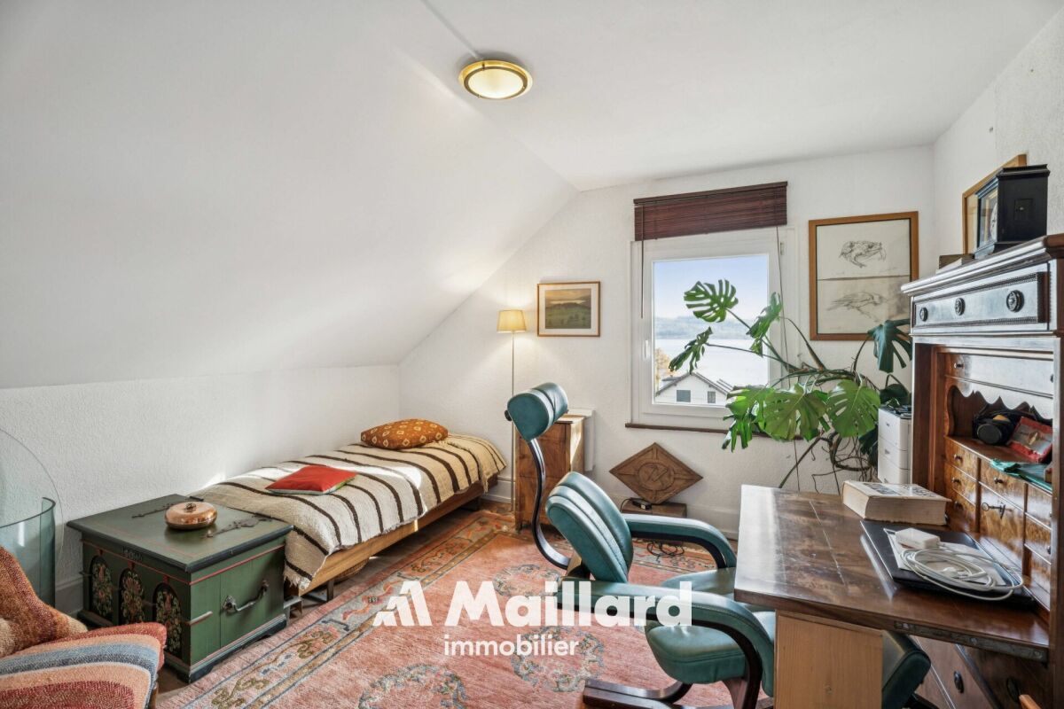Dachzimmer mit Einzelbett und Arbeitsbereich