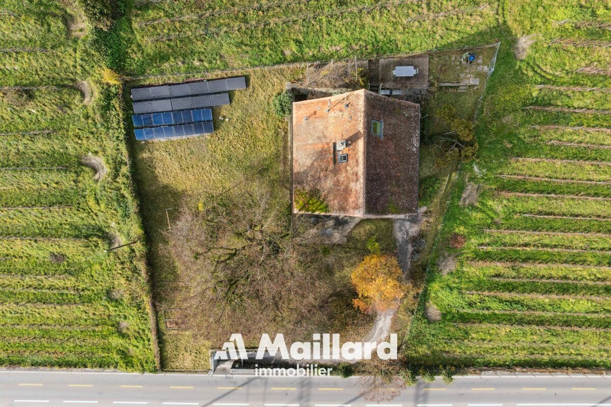 Luftaufnahme eines Hauses mit Solarpanels inmitten von Grünflächen