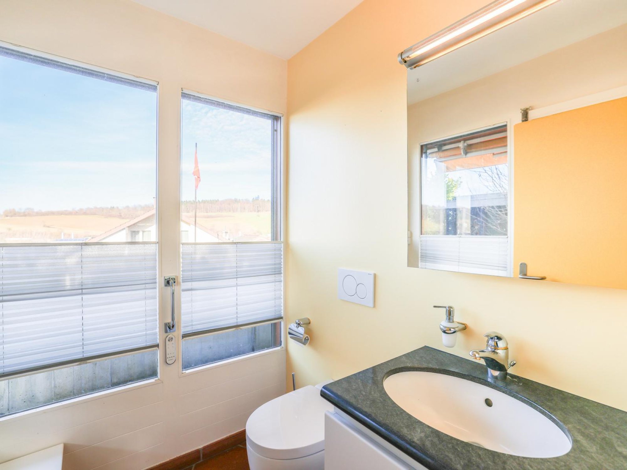 Modernes Gäste-WC mit Waschbecken und Blick nach draußen