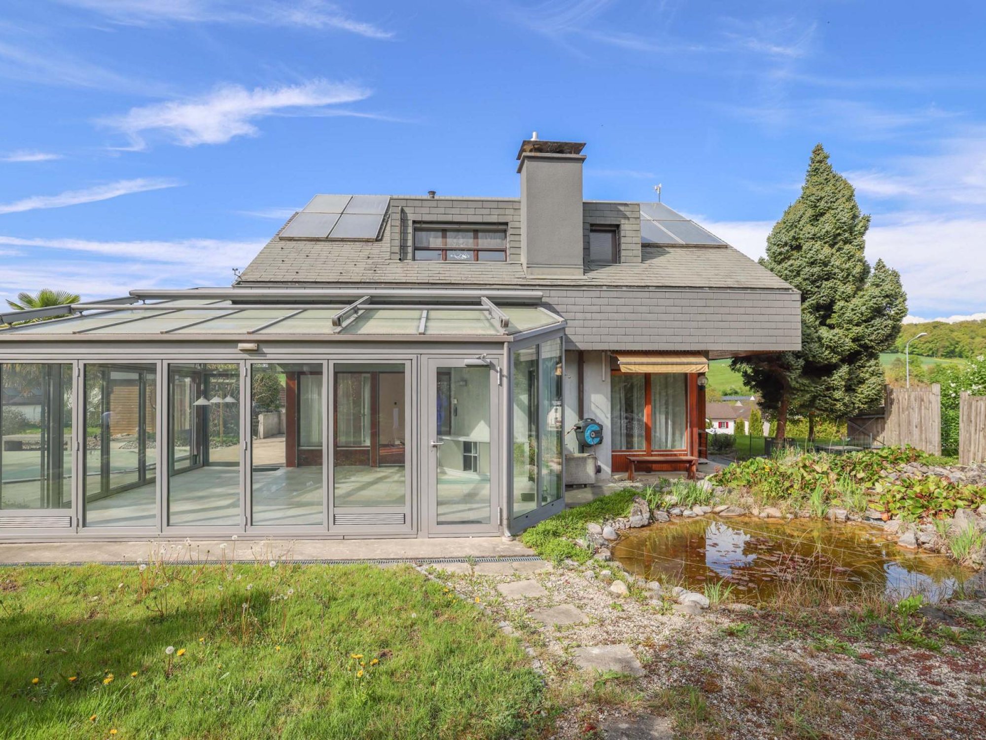 Modernes Haus mit Wintergarten und Garten