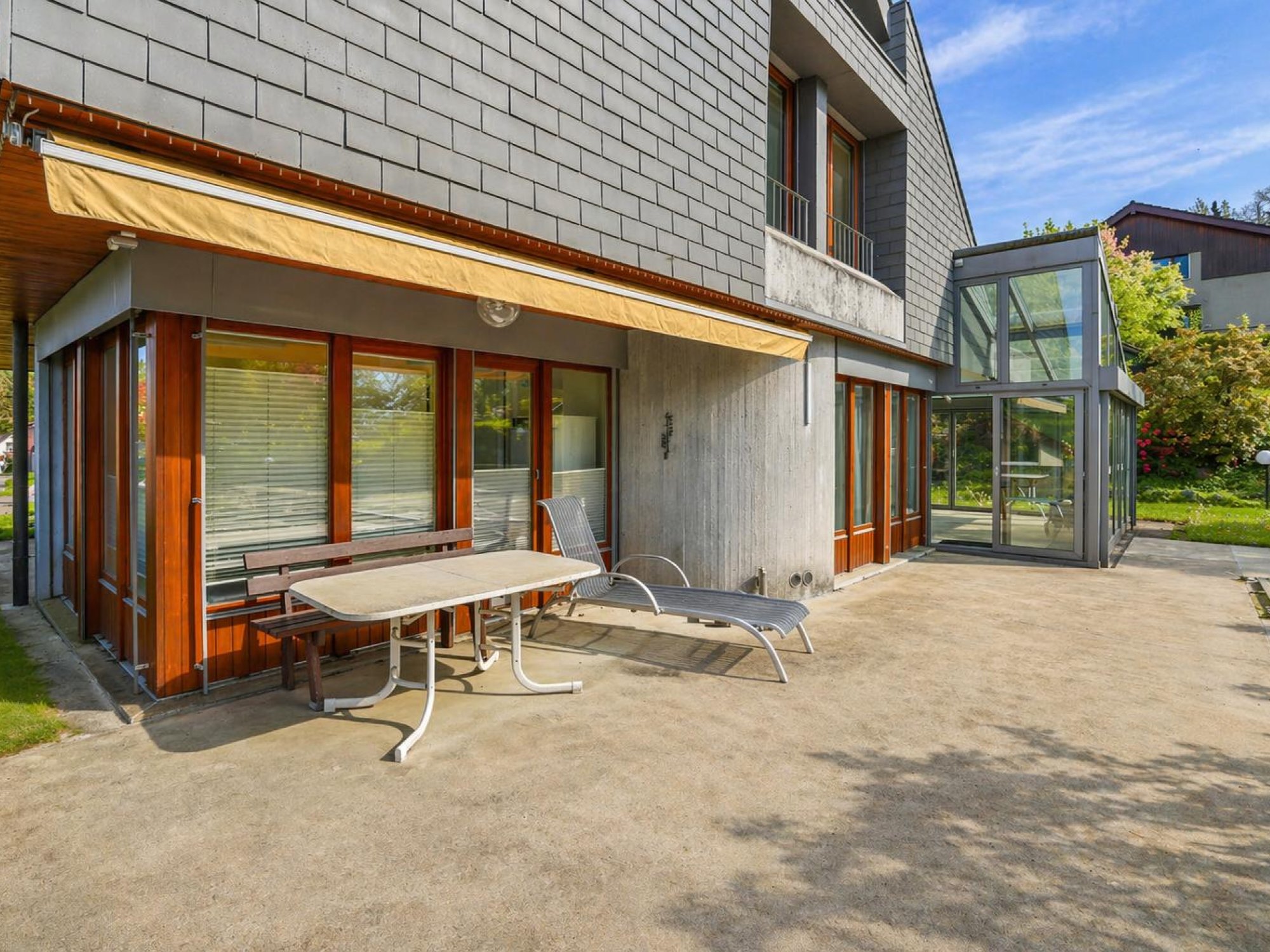 Moderne Außenterrasse mit Wintergartenanbau