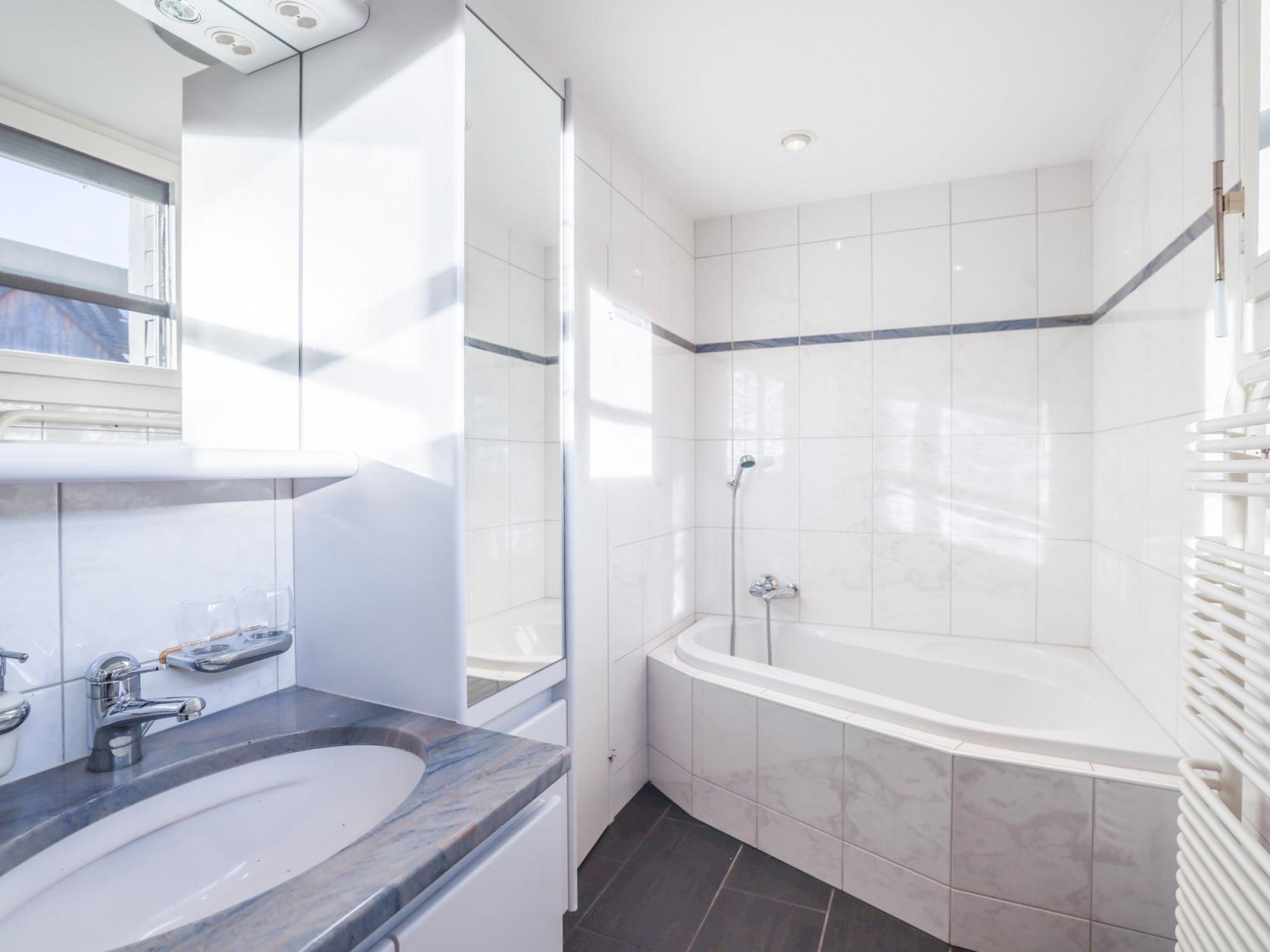 Helles Badezimmer mit Badewanne und Waschtisch