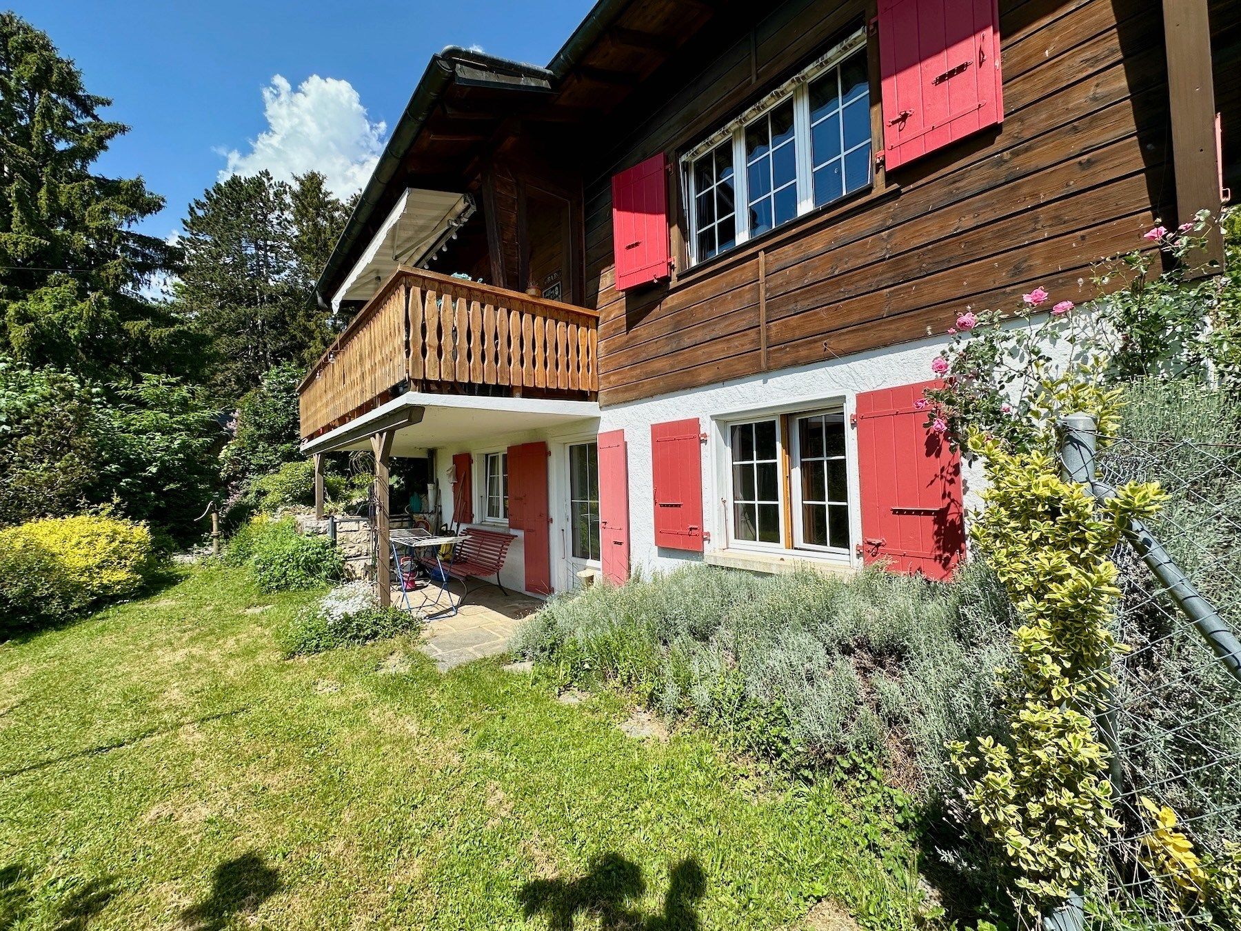 Alpenhaus mit Holzfassade und rotem Fensterläden