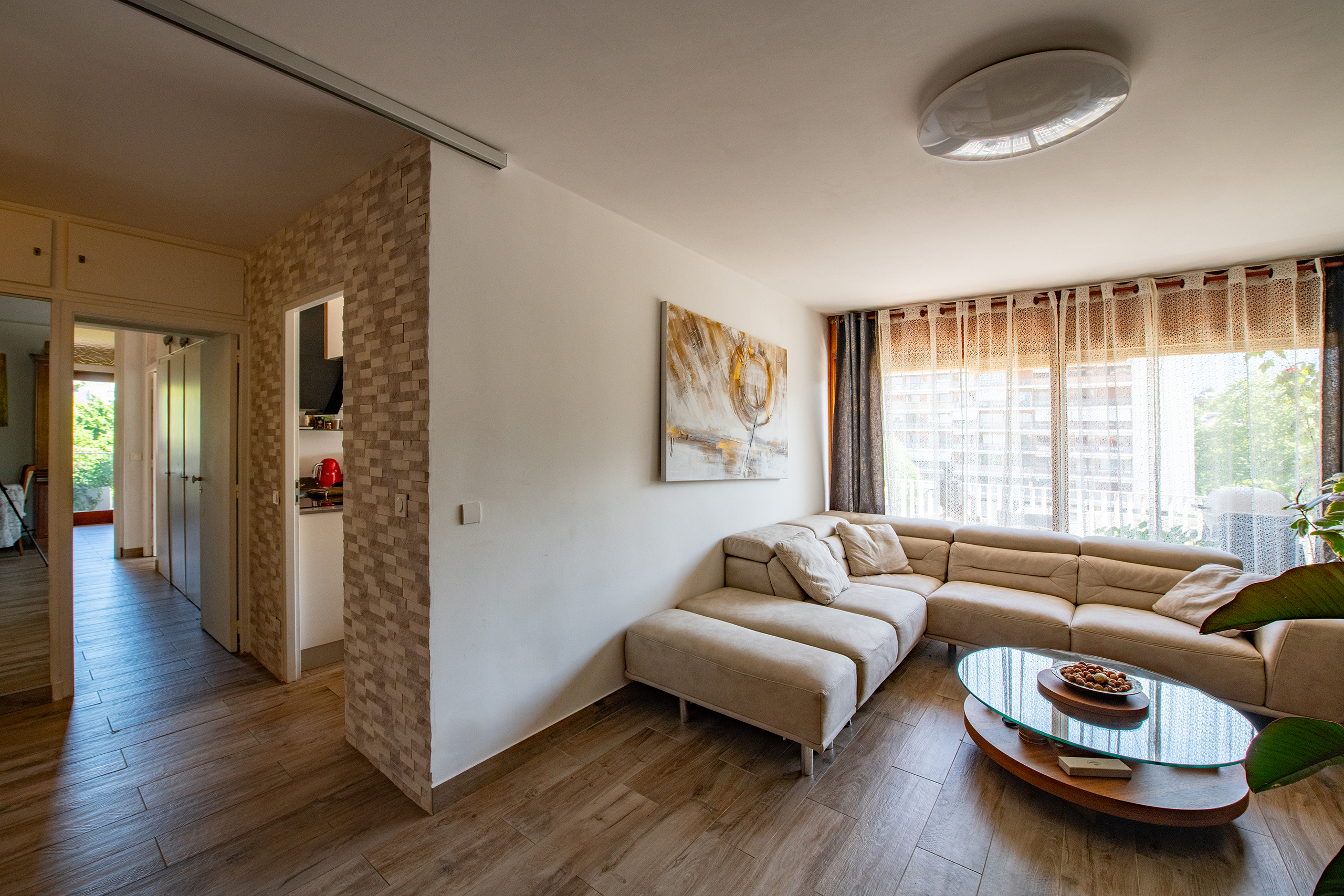 Helles Wohnzimmer mit Ecksofa und großem Fenster