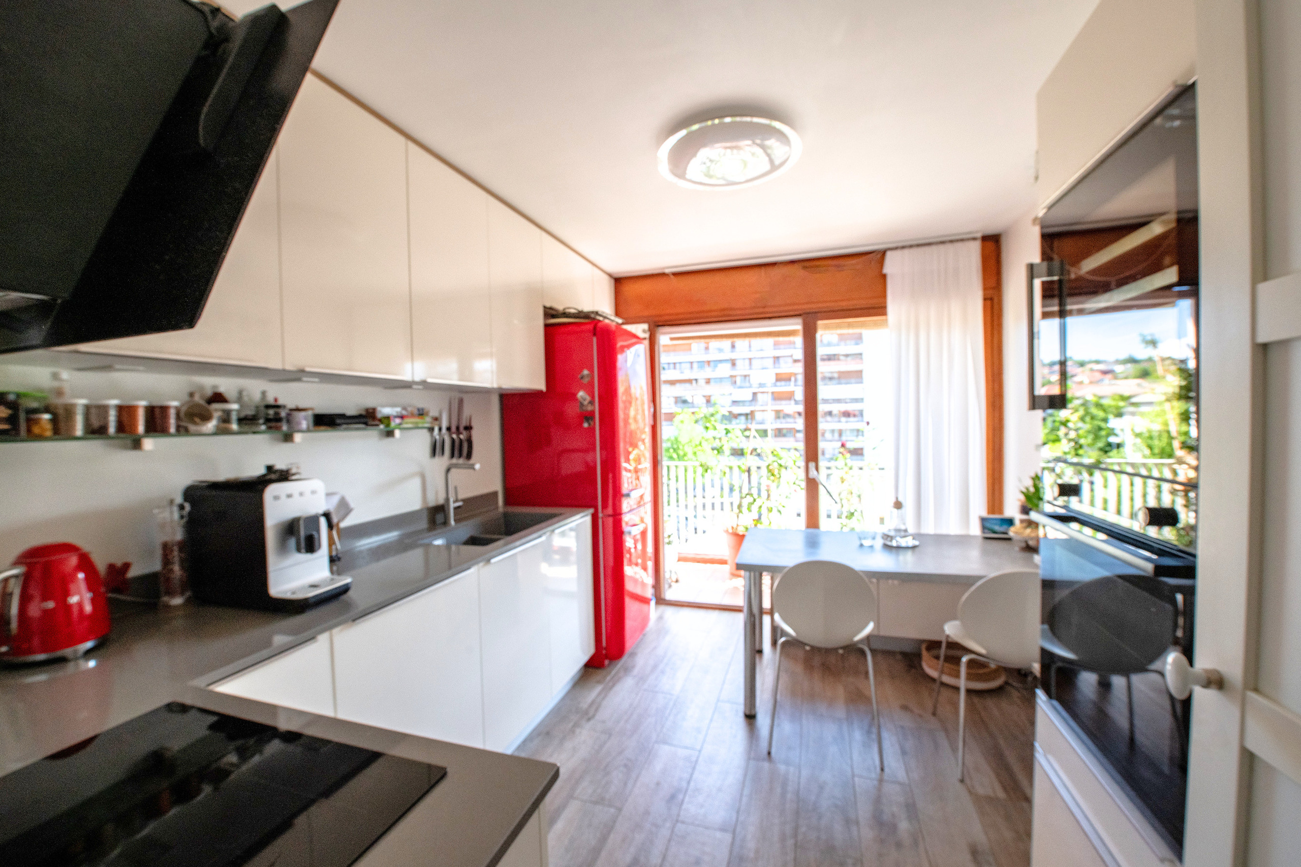 Moderne Küche mit Essbereich und Balkonzugang