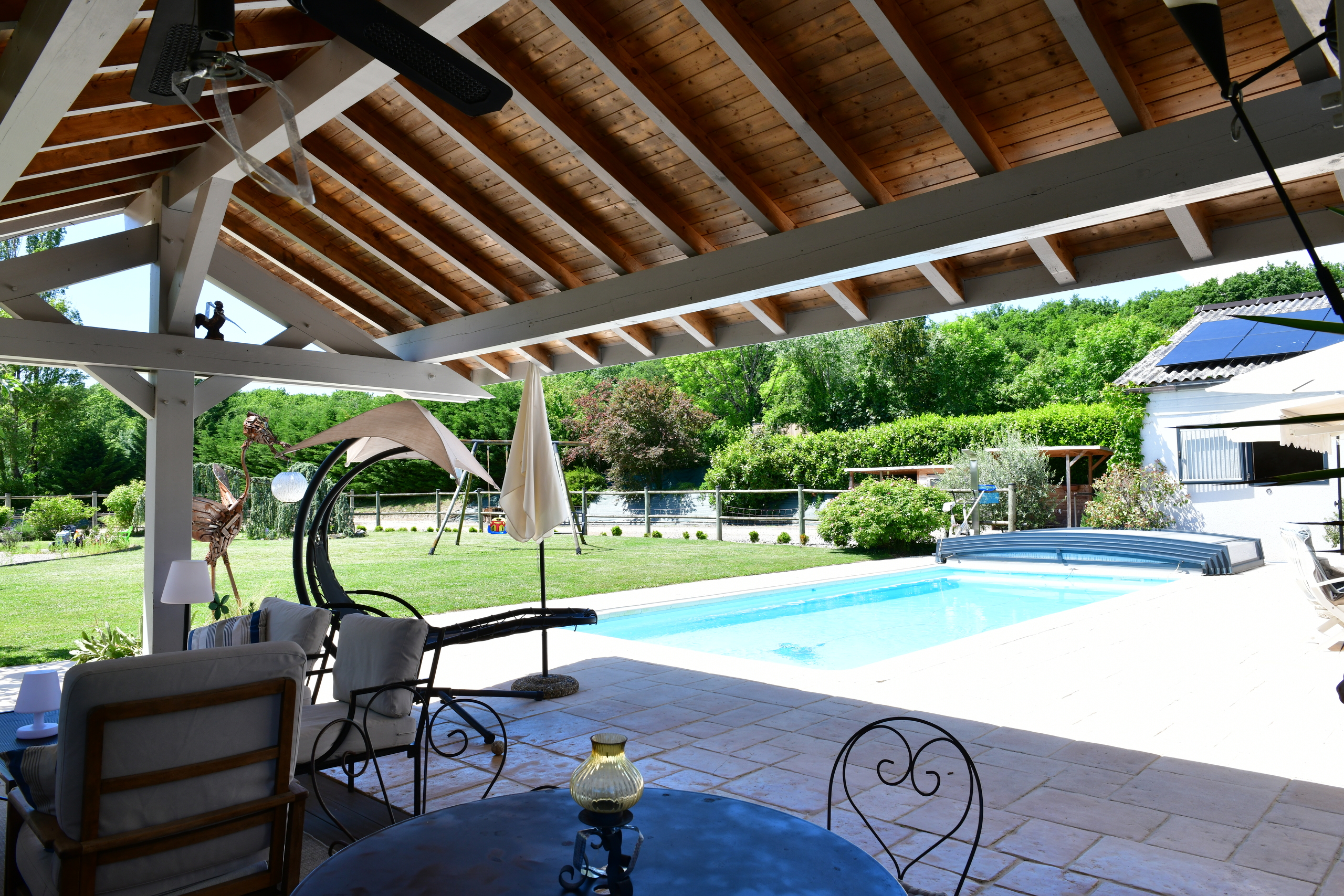 Überdachte Terrasse mit Pool und Garten