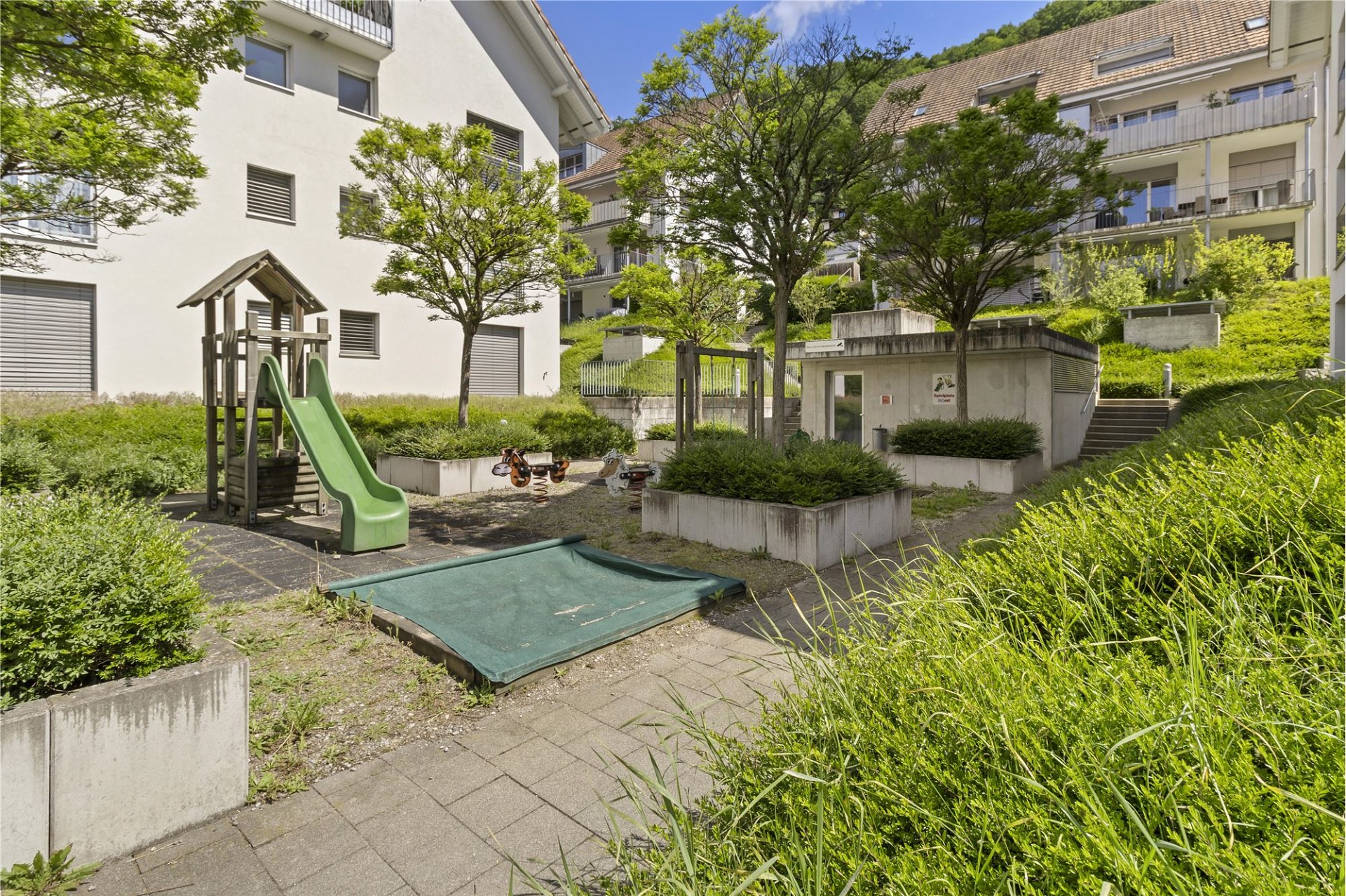 Außenbereich mit Spielplatz und Wohnanlage