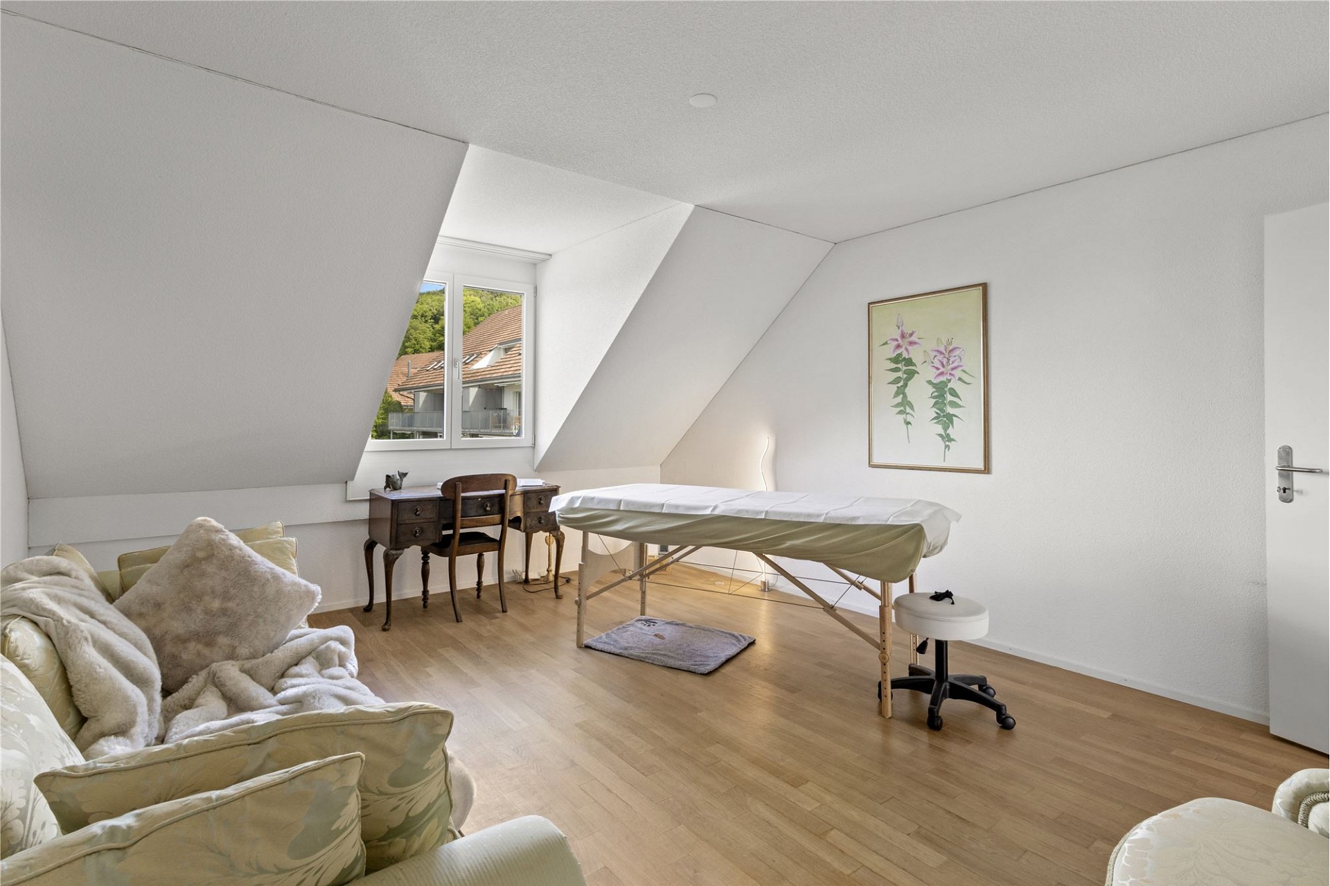 Helles Dachzimmer mit Behandlungsliege