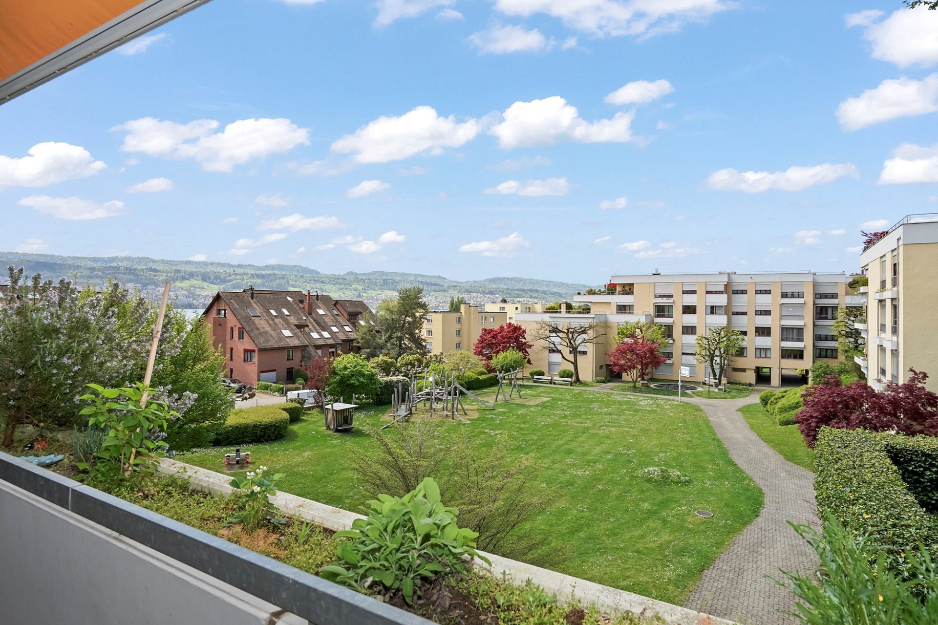 Blick vom Balkon auf Wohnanlage und Garten