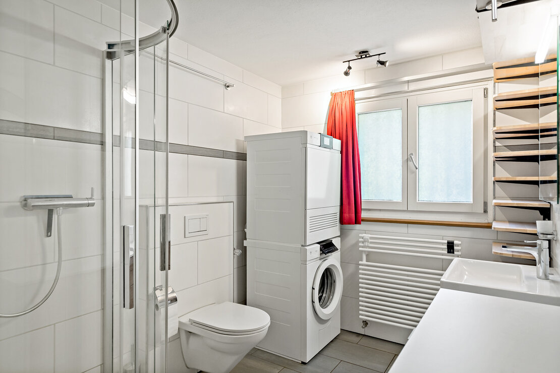 Modernes Badezimmer mit Dusche, WC, Waschtisch und Waschmaschine