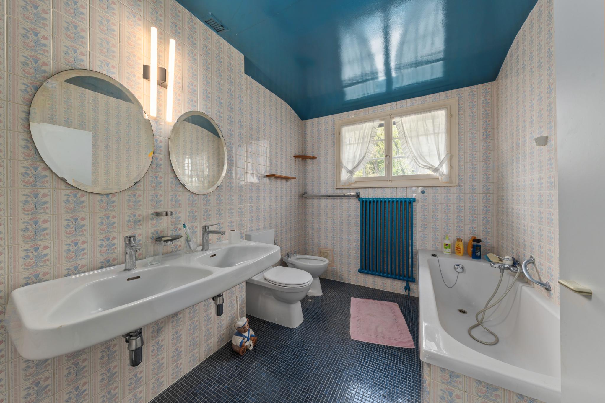 Badezimmer mit bunten Fliesen und blauem Deckenanstrich